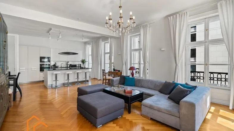 Geräumiger offener Wohn-Essbereich mit moderner Küche, Parkettboden und großen Fenstern.