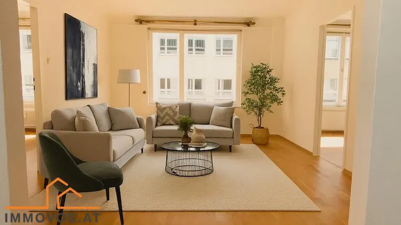 Helles Wohnzimmer mit zwei bequemen Sofas, einem Couchtisch und Blick auf die gegenüberliegenden Gebäude.