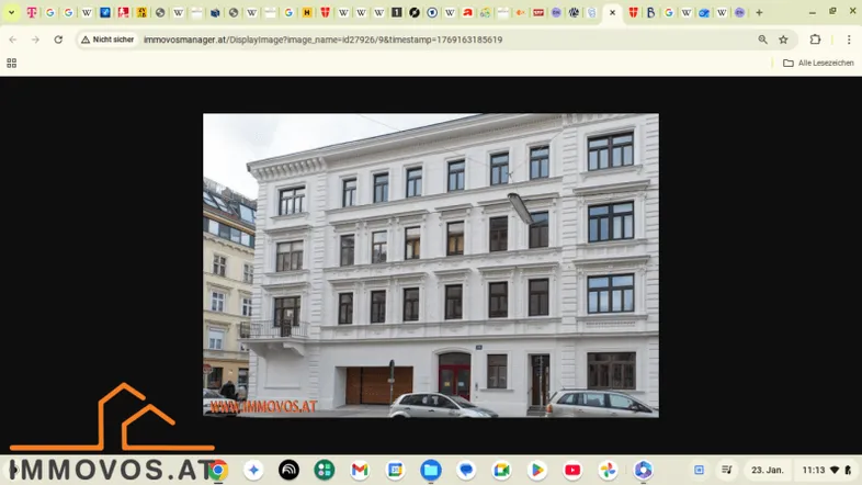Klassische Altbaufassade mit weißen Wänden, großen Fenstern und einem kleinen Balkon im ersten Stock.