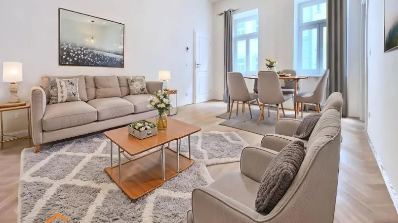 Helles Wohn- und Esszimmer mit modernem Mobiliar, Parkettboden und großen Fenstern.