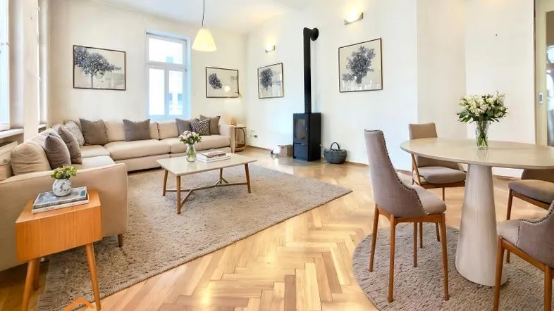 Helles Wohn- und Esszimmer mit Fischgrätparkett, Kaminofen und gemütlicher Einrichtung.