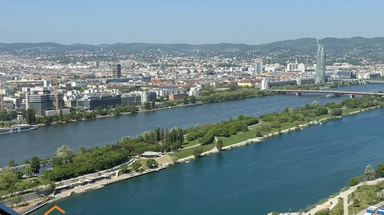 Panoramablick über die Stadt mit Fluss und Bergen im Hintergrund von einem hohen Gebäude.