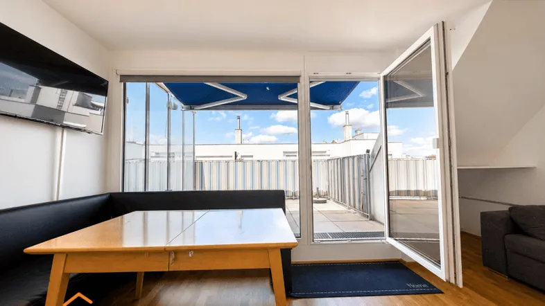 Heller Wohn- und Essbereich mit Holzboden und direktem Zugang zur sonnigen Dachterrasse.