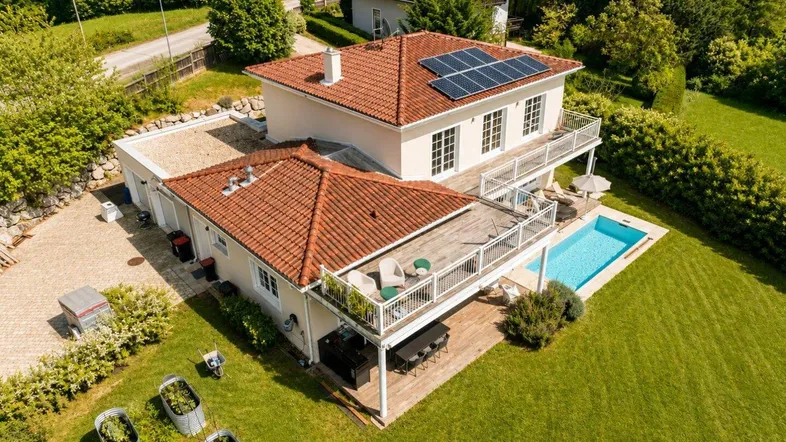 Luftaufnahme des Hauses mit Pool, Terrasse und Photovoltaikanlage auf dem Dach.
