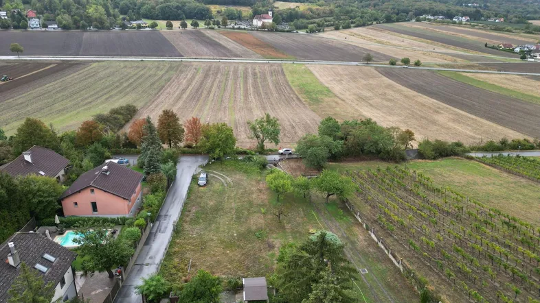 Luftaufnahme eines Wohngebiets mit Feldern, Weinbergen und einzelnen Häusern in ländlicher Umgebung.