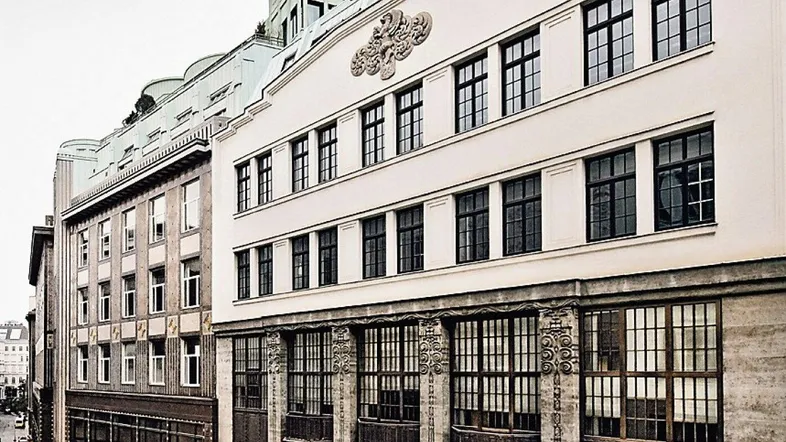 Historische Fassade eines Gebäudes mit vielen Fenstern und architektonischen Details in der Stadt.