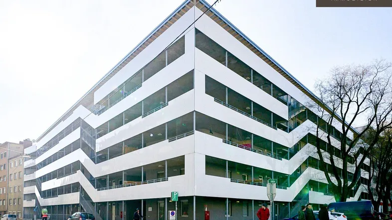 Modernes Parkhaus mit markanter, zickzackförmiger Fassade und mehreren Ebenen in urbaner Umgebung.
