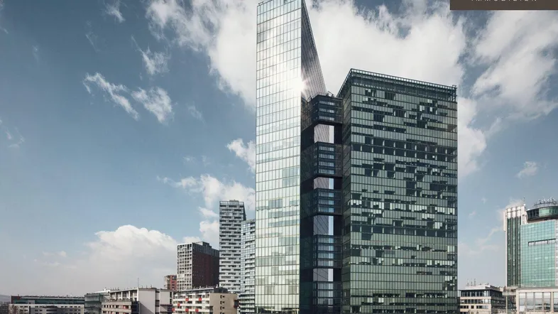 Moderne Hochhäuser mit Glasfassaden unter einem bewölkten Himmel in einer städtischen Umgebung.