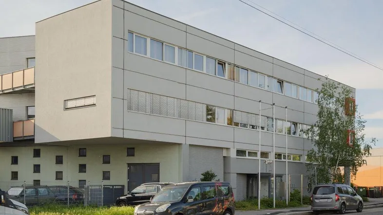 Modernes Bürogebäude mit klarer Architektur und großen Fensterfronten an einer Straße gelegen.