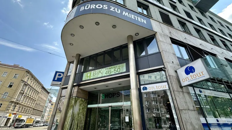 Moderne Geschäftsfassade mit Büroschildern und großen Fenstern, die eine städtische Umgebung widerspiegeln.