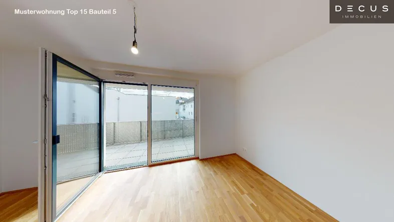 Helles Wohnzimmer mit Holzboden und bodentiefen Fenstern, die Zugang zu einer Terrasse bieten.