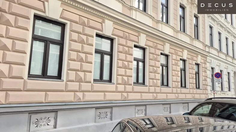 Fassade eines historischen Gebäudes mit vielen Fenstern und dekorativen Elementen im Stadtbild.