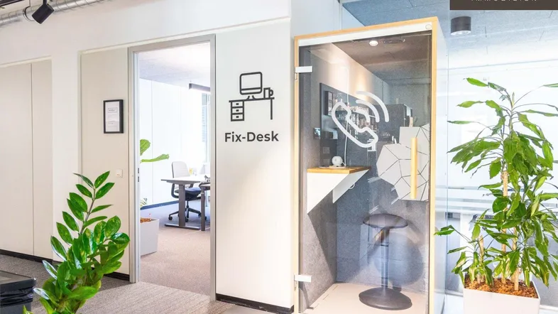 Modernes Büro mit einer schallgedämmten Telefonzelle und Zugang zu einem weiteren Arbeitsbereich.
