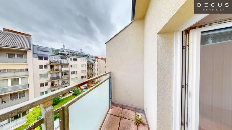 Balkon mit Blick auf umliegende Wohngebäude und einfachem Metallgeländer.
