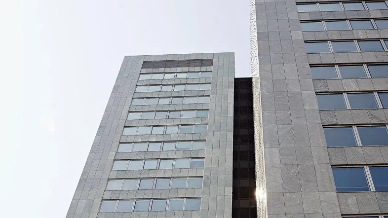 Moderne Hochhausfassade mit vielen Fenstern und klarem Himmel, die eine beeindruckende Architektur zeigt.