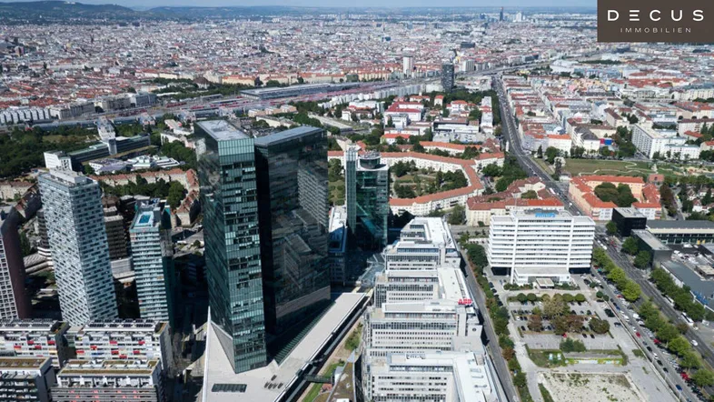 Luftaufnahme einer modernen Stadtlandschaft mit Hochhäusern und weitreichendem Blick über die urbanen Strukturen.