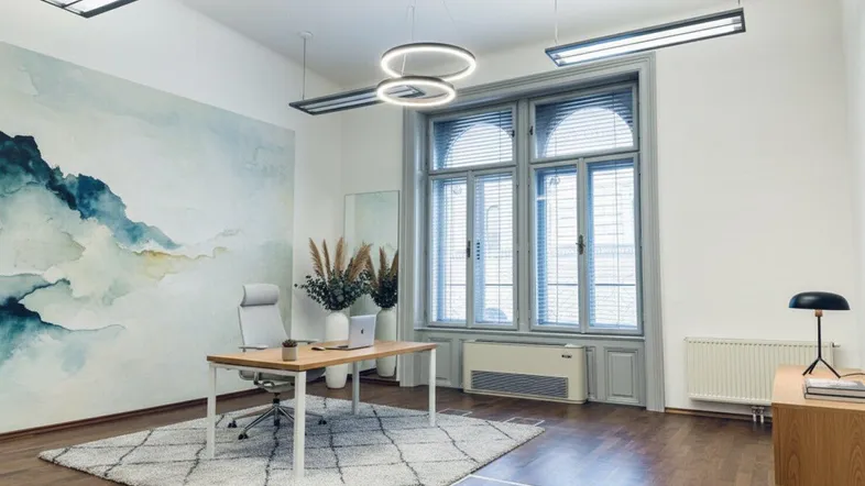 Modernes Büro mit Holzboden, großen Fenstern und stilvoller Wanddekoration, ideal für kreatives Arbeiten.