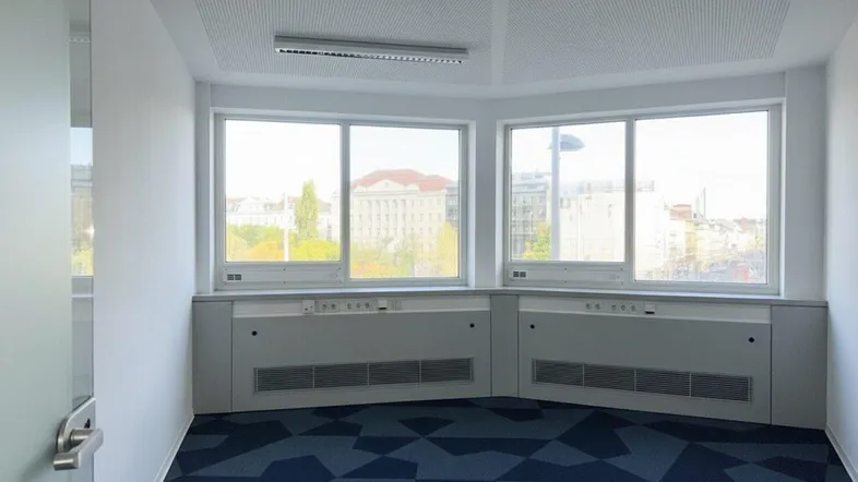 Helles Eckbüro mit großen Fenstern, die viel Tageslicht hereinlassen und einen weiten Blick bieten.