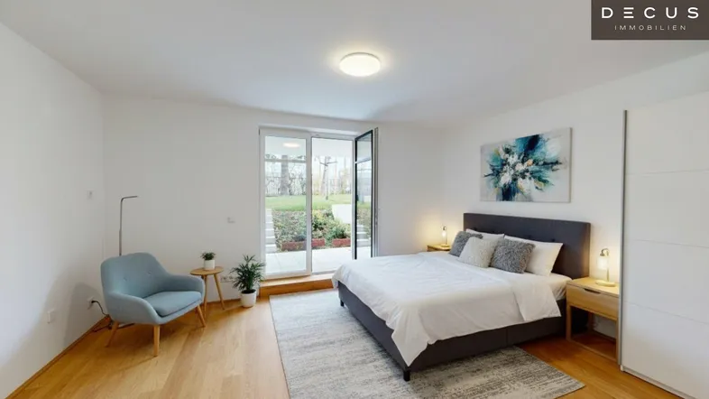 Helles Schlafzimmer mit Holzboden, modernem Doppelbett und direktem Zugang zum Garten.