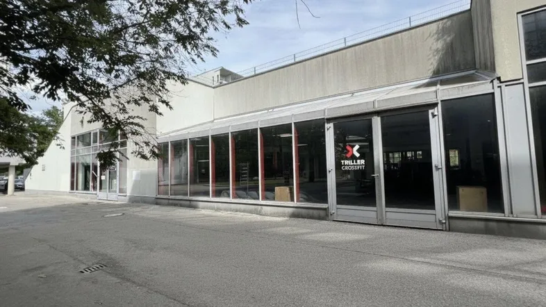 Außenansicht eines modernen Geschäftsgebäudes mit großen Glasfronten und einem CrossFit-Studio.
