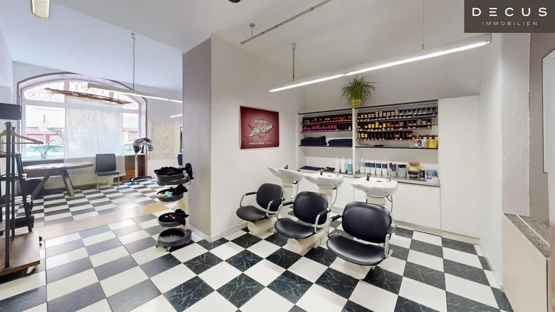 Geräumiger Friseursalon mit mehreren Waschbecken und markantem schwarz-weißem Fliesenboden.
