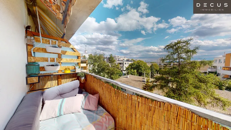 Gemütlicher Balkon mit Sitzgelegenheiten und Bambusverkleidung, bietet einen Blick ins Grüne.