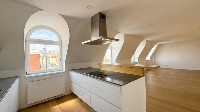 Moderne Küche mit Kochinsel, Dachschrägen und Rundbogenfenster in einem offenen Wohnbereich.