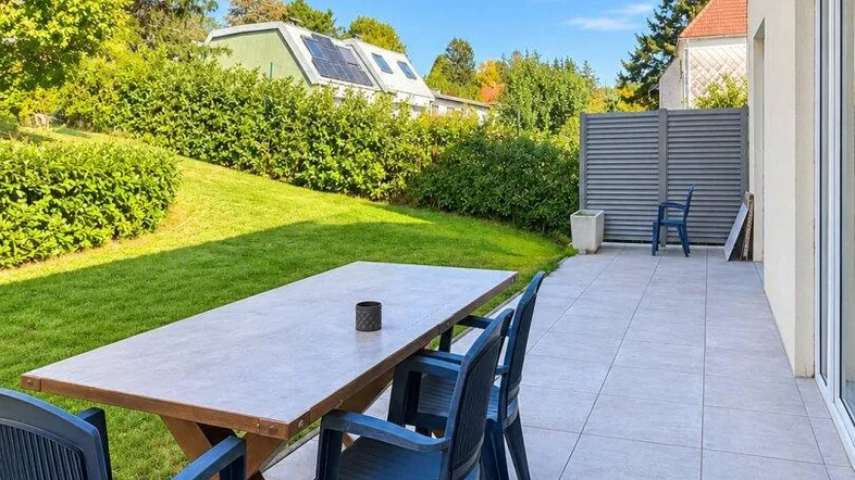 Geräumige Terrasse mit Essbereich und direktem Zugang zum gepflegten Garten.