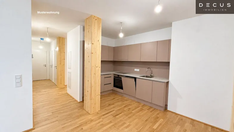Moderne Einbauküche mit hellen Fronten und Holzbalken in einem offenen Wohnbereich.