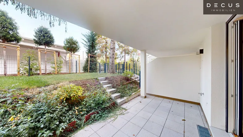 Überdachte Terrasse mit direktem Zugang zum Garten und Treppen zu einer oberen Ebene.