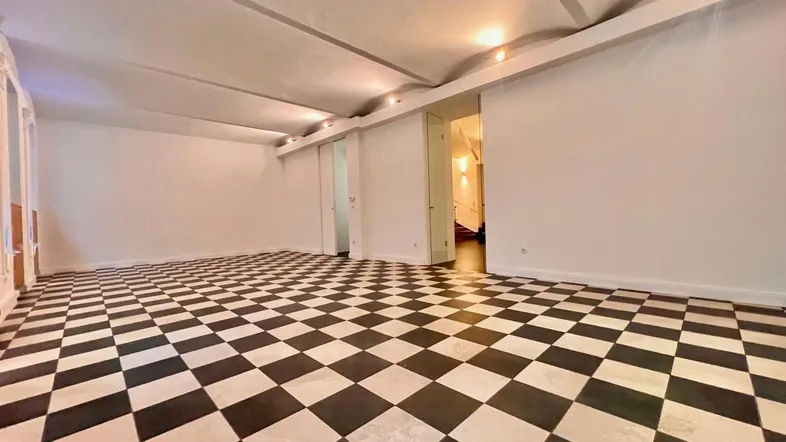 Großer, heller Raum mit markantem schwarz-weißem Schachbrettmuster-Fliesenboden und gewölbter Decke.