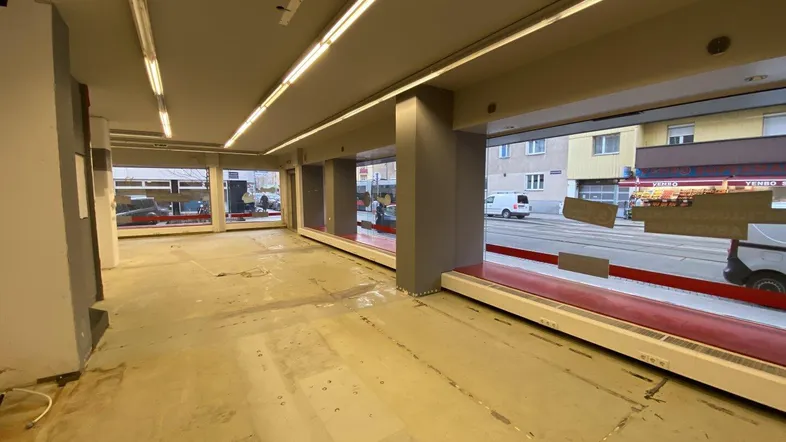Geräumiger Geschäftsraum mit großen Schaufenstern zur Straße, bereit für den Innenausbau und neue Nutzung.