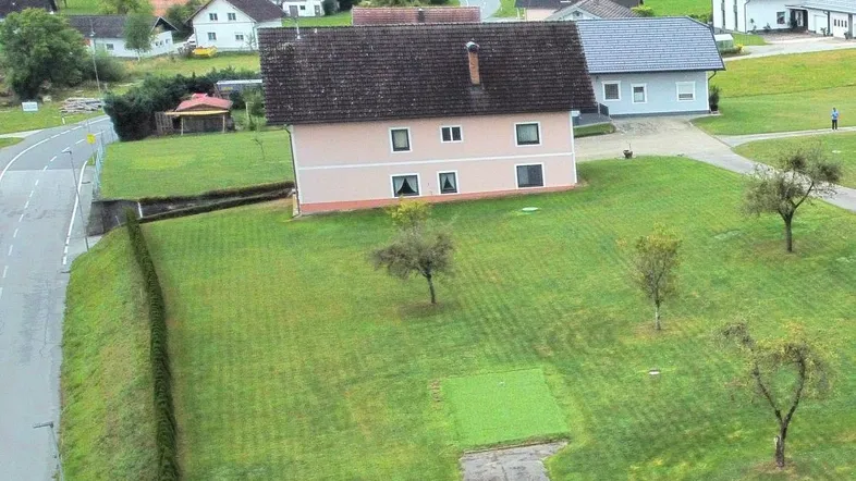 Luftaufnahme eines Einfamilienhauses mit großem Grundstück und Blick auf die umliegende Landschaft.