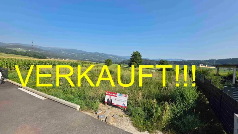 Verkauftes Grundstück in ländlicher Umgebung mit Blick auf Felder und entfernte Hügel.