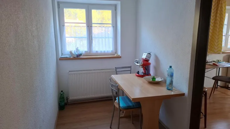 Kleiner Essbereich mit Fenster, Holzboden und Heizkörper, ideal für Mahlzeiten.