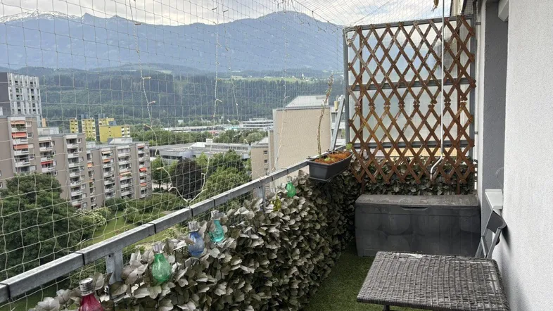 Gemütlicher Balkon mit Kunstrasen, kleinem Tisch und beeindruckendem Bergblick.