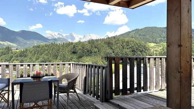 Gemütliche Holzterrasse mit Sitzgelegenheiten und atemberaubendem Bergblick.