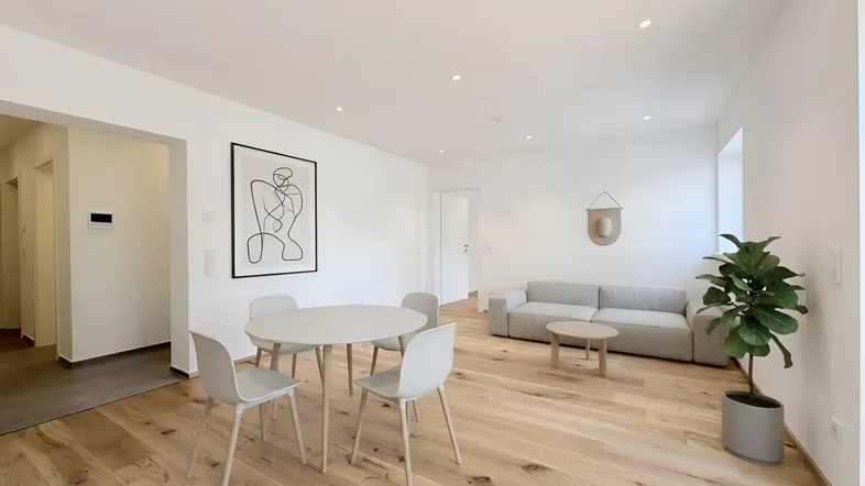 Helles, modern eingerichtetes Wohn-Esszimmer mit Holzboden und minimalistischer Dekoration.