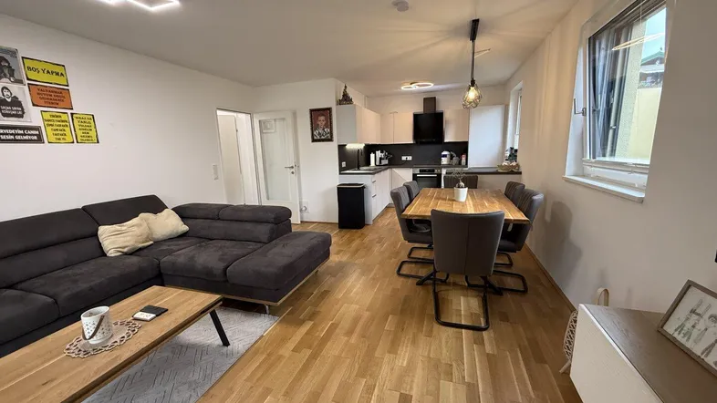 Offener Wohn-Essbereich mit integrierter Küche, Holzboden und moderner Einrichtung.