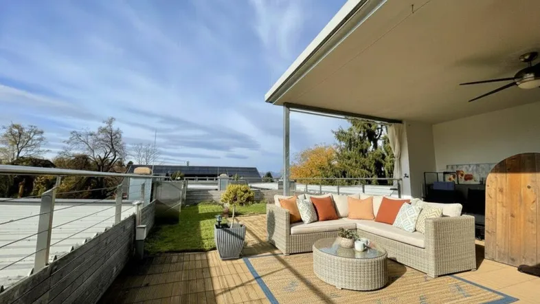 Geräumige Dachterrasse mit bequemen Loungemöbeln, Sonnenschutz und Blick in die Umgebung.