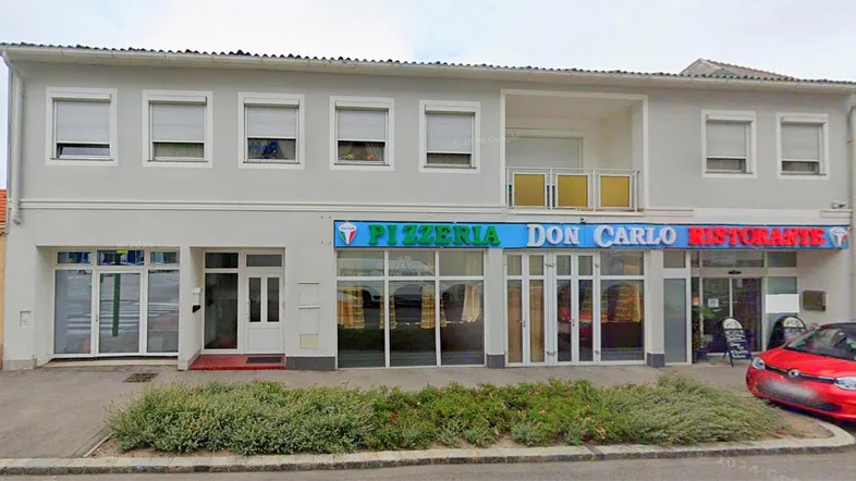 Fassade eines Gebäudes mit Geschäftsflächen im Erdgeschoss und Wohnungen darüber.