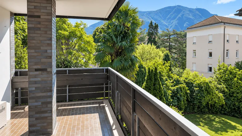 Geräumiger Balkon mit Fliesenboden und beeindruckendem Blick auf die umliegenden Berge.