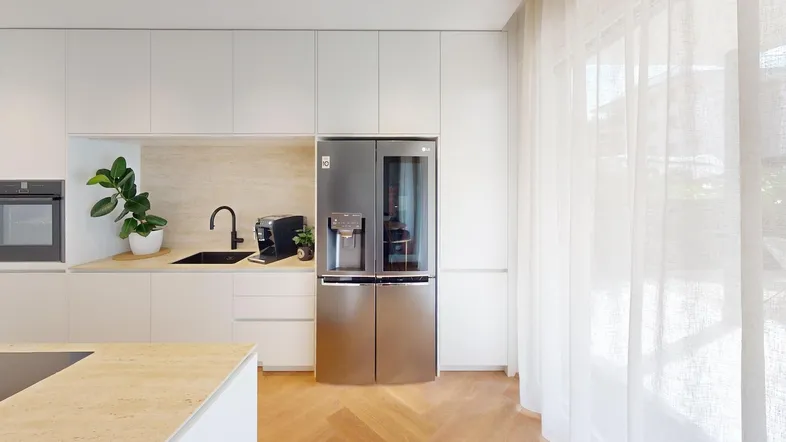 Moderne Küche mit integriertem Kühlschrank, Backofen und hellem Holzparkettboden.