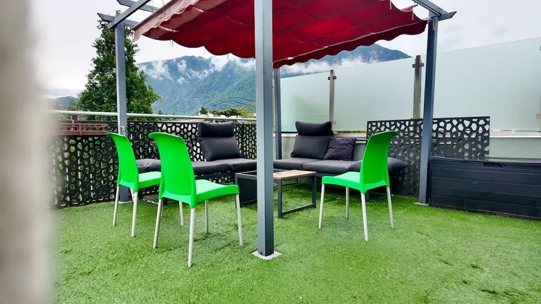Gemütliche Dachterrasse mit Pergola, Sitzgelegenheiten und beeindruckendem Bergblick.