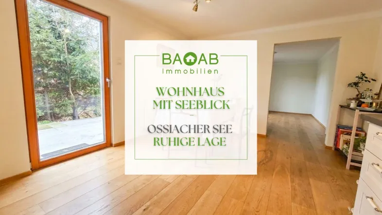 Heller Wohnbereich mit Holzboden und großem Fenster, das den Blick ins Grüne freigibt.