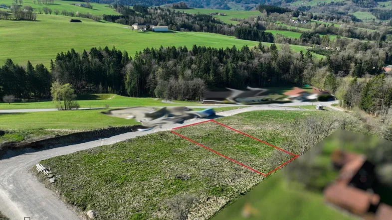 Luftaufnahme eines grünen Grundstücks mit markierter Fläche und weitem Blick auf die umliegende Hügellandschaft.