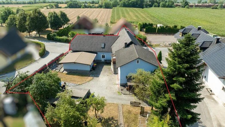 Luftaufnahme des Anwesens mit roter Umrandung, umgeben von Feldern und einem Fluss im Hintergrund.