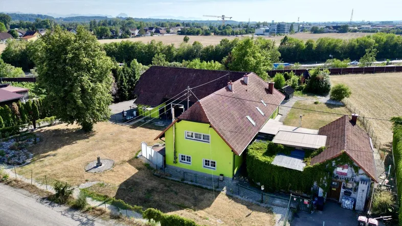 Luftaufnahme des Anwesens mit Hauptgebäude, Nebengebäude und weitläufigen Grünflächen in ländlicher Umgebung.