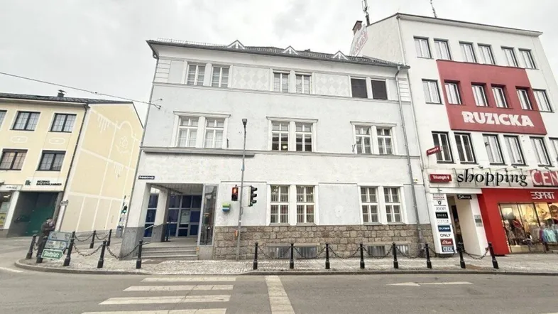 Historisches Gebäude an einer belebten Straße mit Geschäften im Erdgeschoss und Wohnungen darüber.