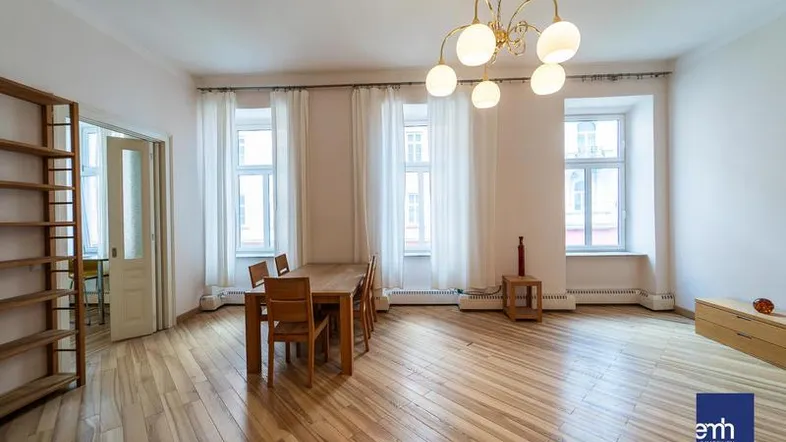 Heller Wohn- und Essbereich mit Holzboden, hohen Decken und großzügigen Fenstern.